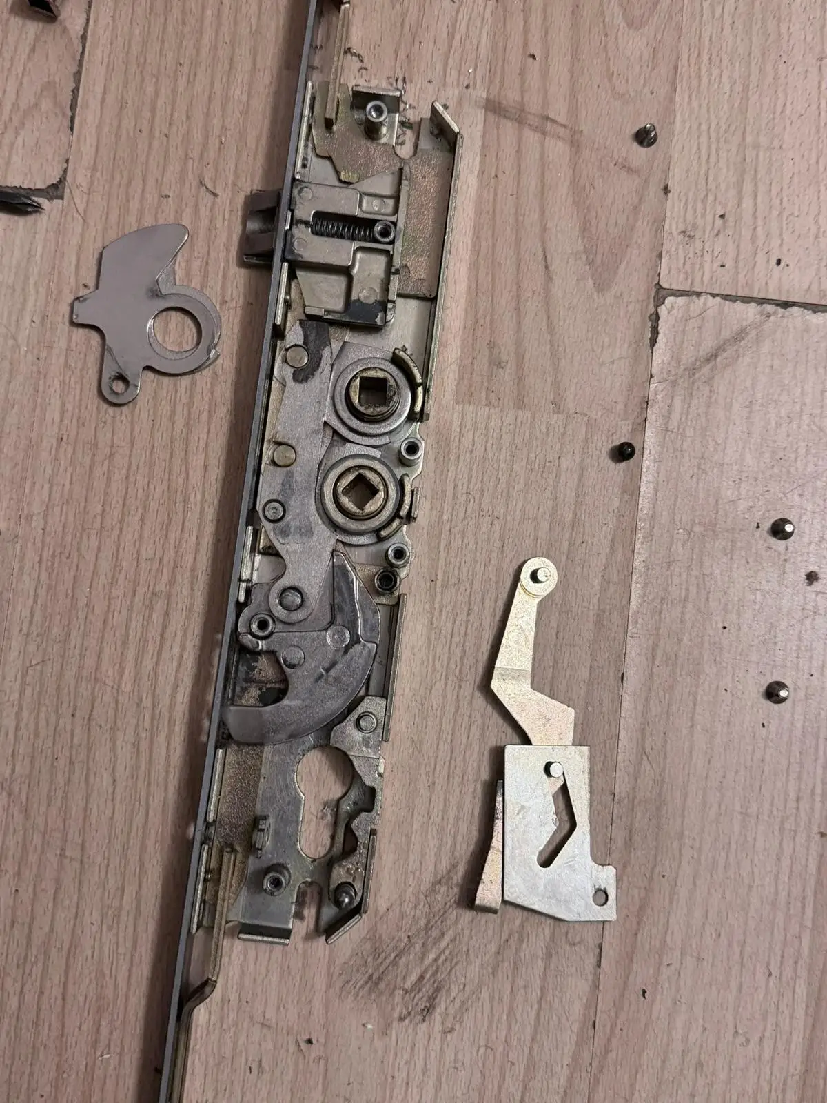 A multipoint lock gearbox with loose internal parts beside it